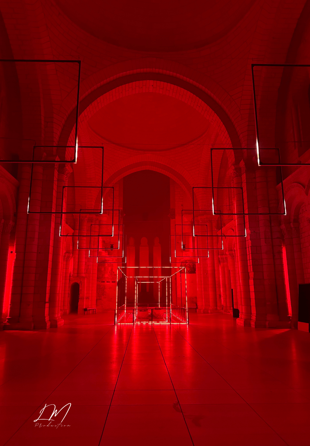 Architecture d’un lieu patrimonial illuminée en rouge lors d’un événement, photographiée par LM Production